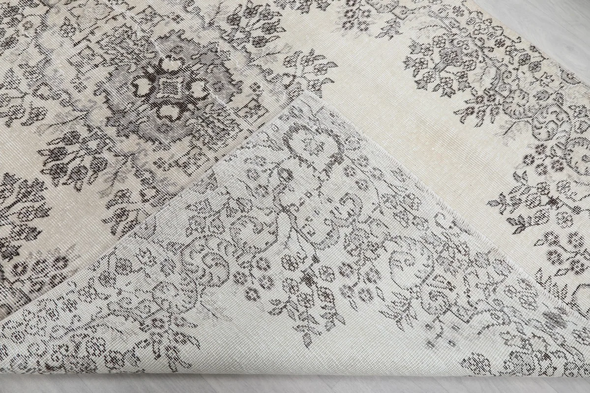 Corner of the rug folded to reveal the cotton foundation and hand-knotted construction