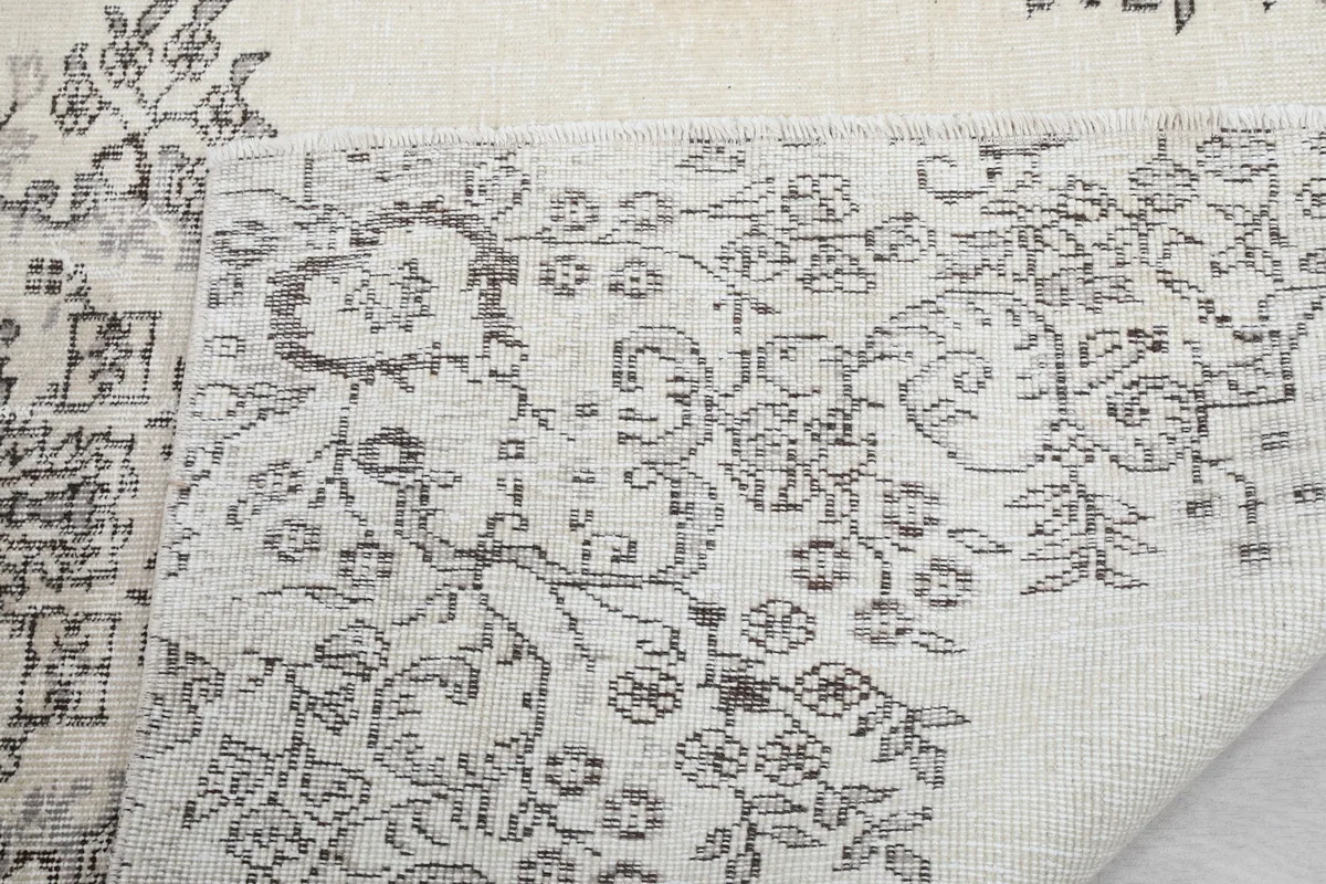 Close-up of the rug's edge, showing the short fringe and the back of the weave