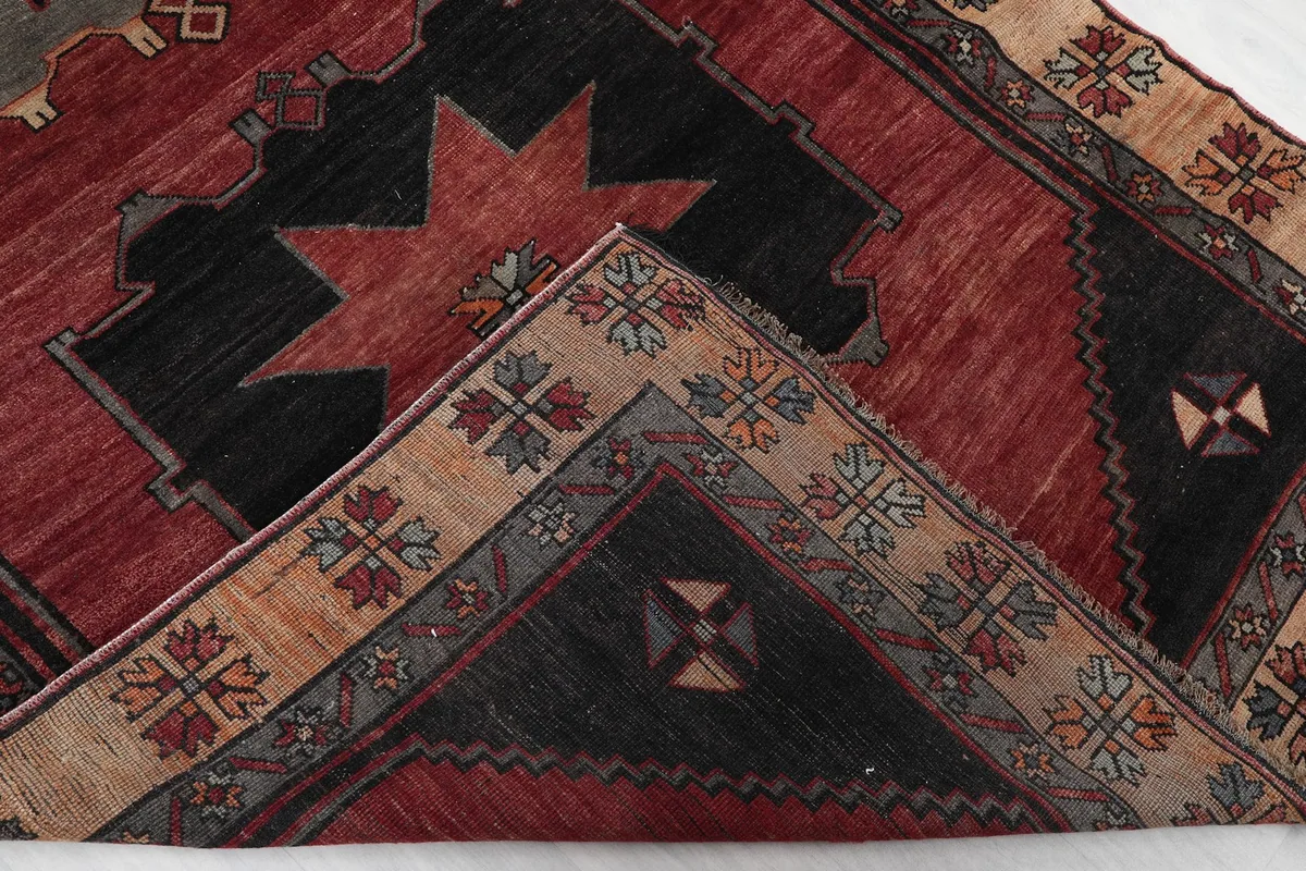 Folded corner of the rug revealing the thickness of the wool pile and cotton foundation