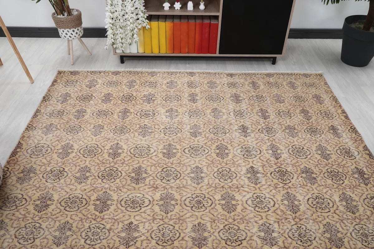 Overhead view of the tan and gray rug placed in a room, highlighting its full design