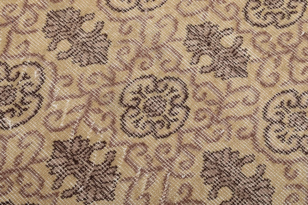 Close-up of the hand-knotted wool pile showing the tan and gray pattern and texture