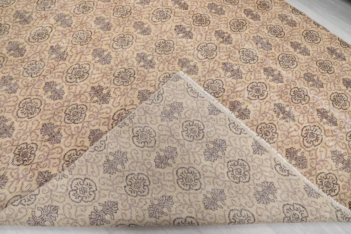 Folded corner of the rug revealing the cotton foundation and the reverse side of the pattern