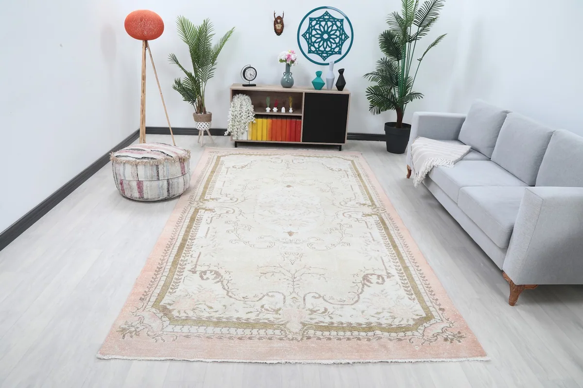 Ivory and rose area rug in a modern living room setting with a gray sofa