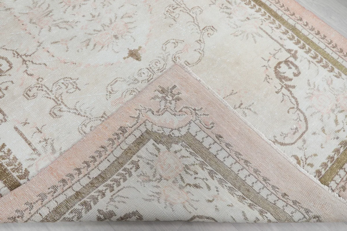 Corner of the rug folded back, showing the cotton foundation and reverse side
