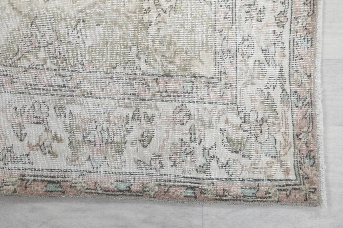 Detailed view of the rug's border design, highlighting the muted colors and hand-knotted texture