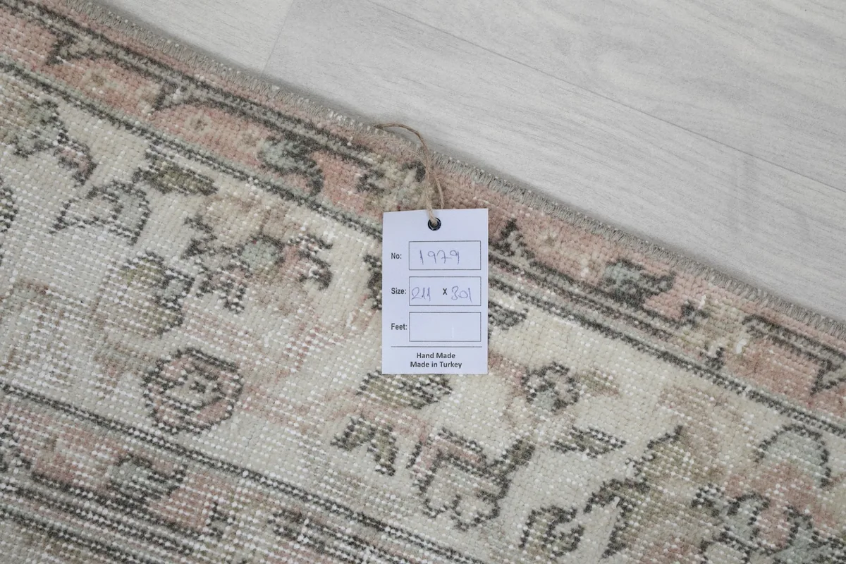 Close-up of the rug's corner with a product tag, showing the woven texture and fringe