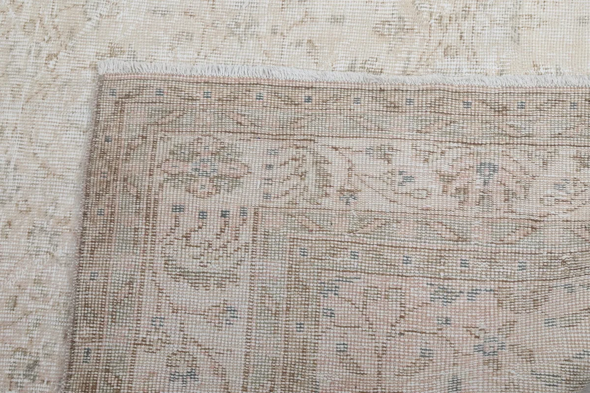 Close-up of a rug corner from the top, showing the fine details of the floral and geometric patterns.