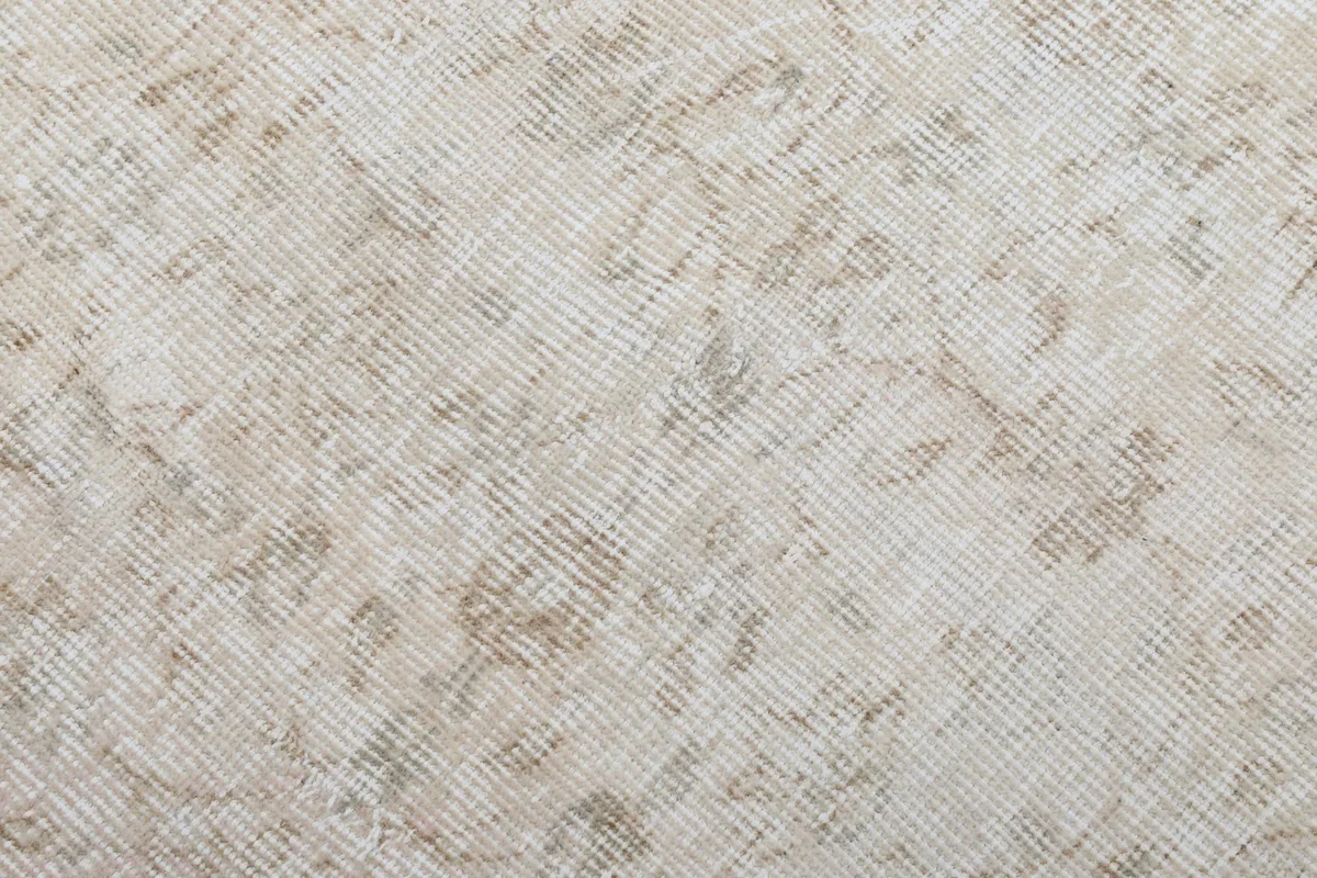 Close-up of the low wool pile, showing the hand-knotted texture and soft color variations.