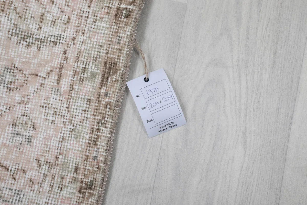 Product tag attached to the rug, indicating its hand-knotted origin and material.