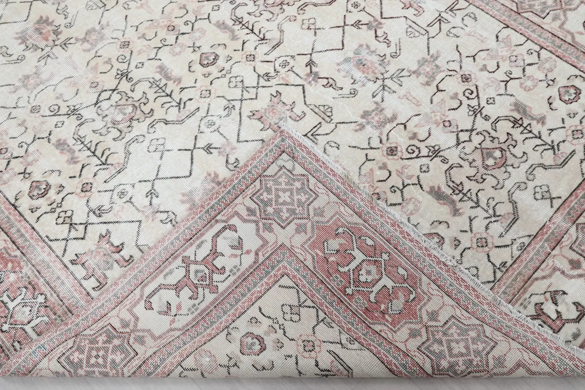 Corner of the rug folded back to reveal the back of the weave and foundation