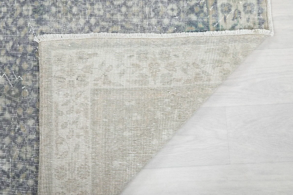 Close-up of the rug's underside, revealing the tightly woven cotton foundation and knotting