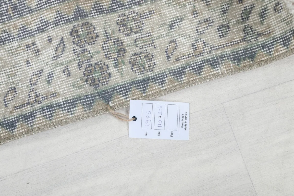 Detail of the rug's edge and a product tag, indicating origin and material