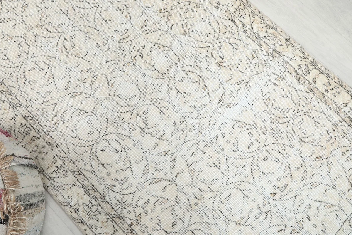 Diagonal view across the rug highlighting the subtle floral and geometric motifs
