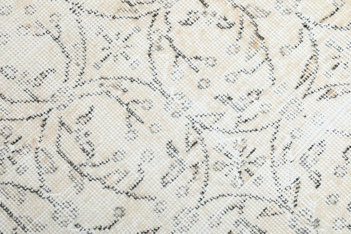 Close-up of the hand-knotted wool pile and intricate charcoal design