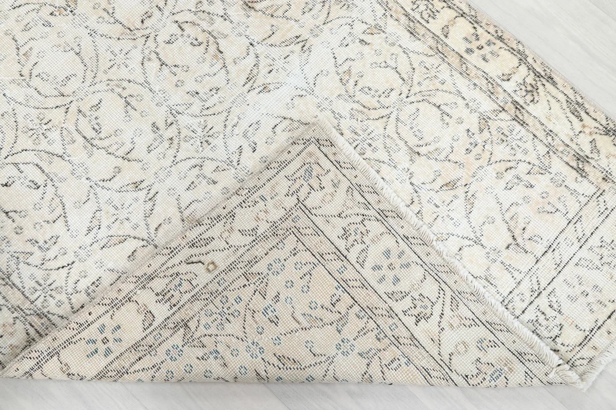 Corner of the rug folded to reveal the back and knotting detail