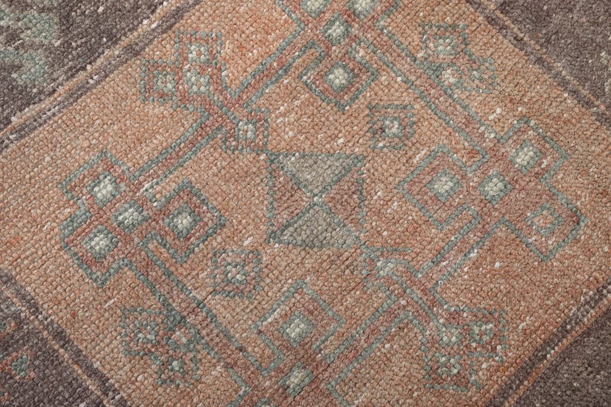 Extreme close-up of the hand-knotted wool pile, showing the intricate geometric design