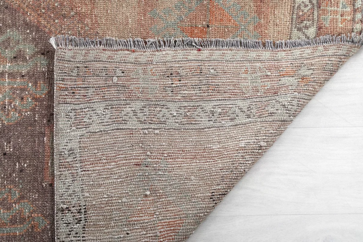 Corner of the rug's back, revealing the tight weave and quality of craftsmanship