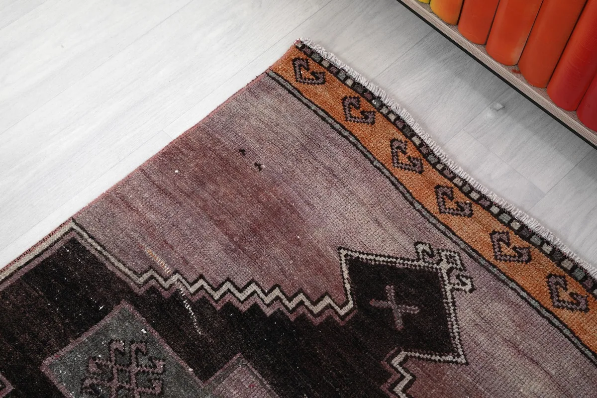 Close-up of the upper border and a section of the runner, showing wear and tan accents.