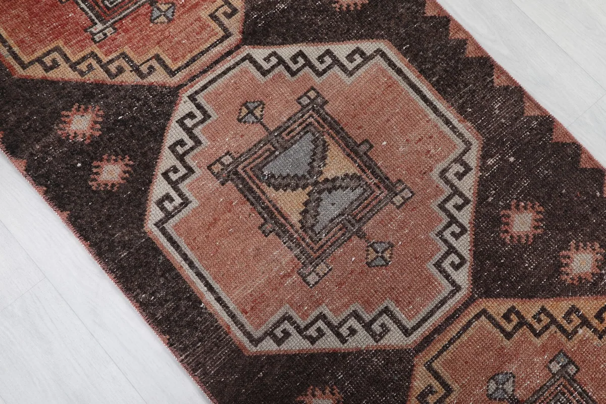 Close-up of a geometric motif with gray and tan details, showing texture and color variations