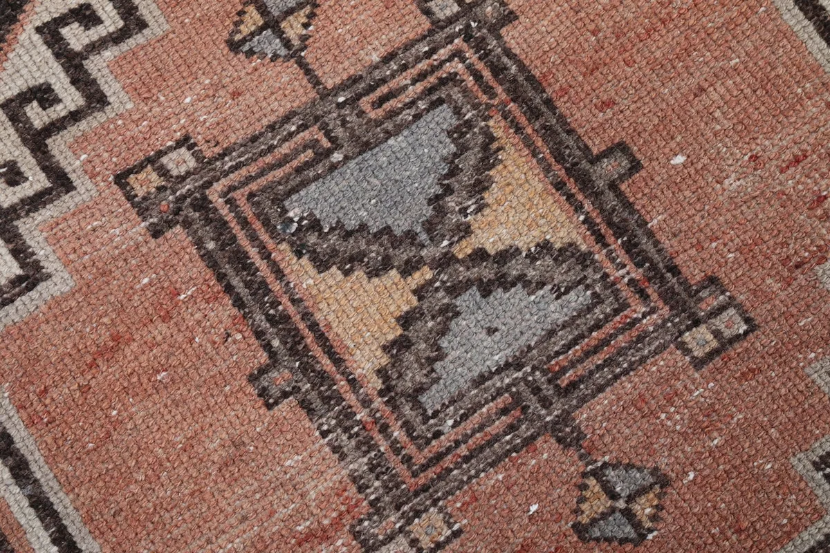 Extreme close-up of the low wool pile and hand-knotted texture of the rug