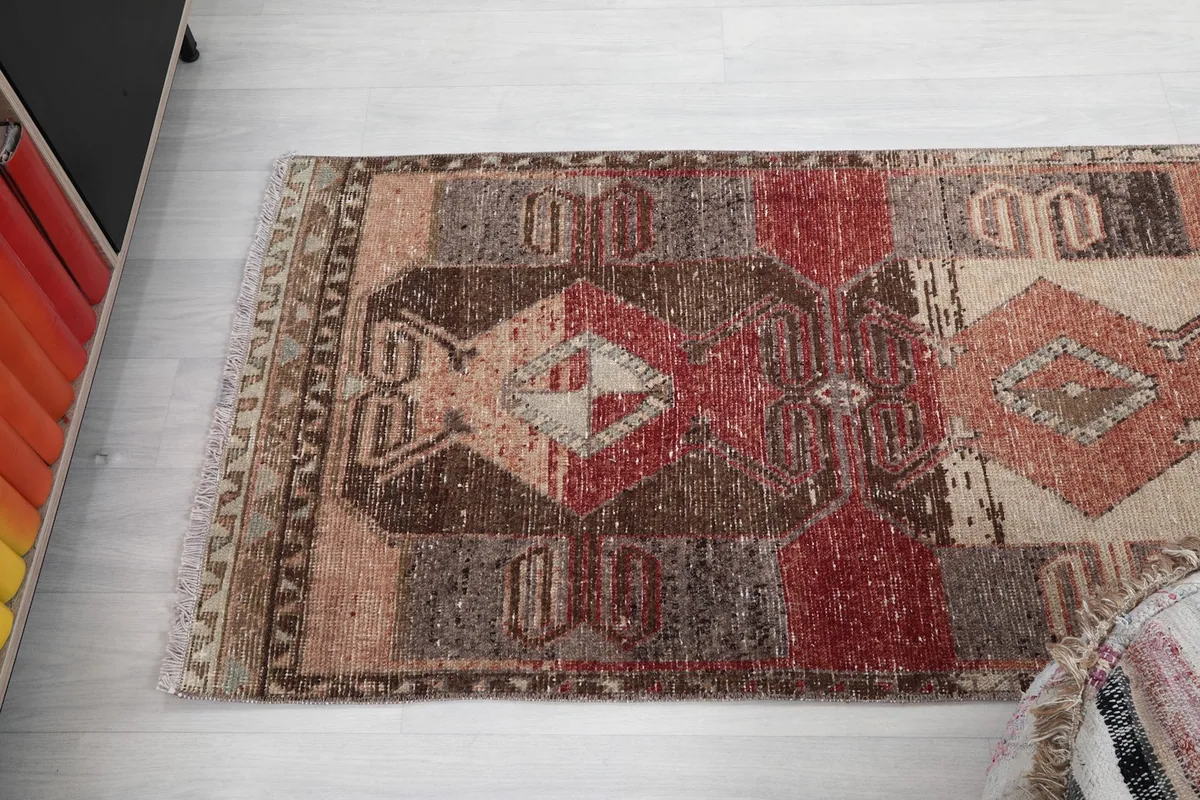 Angled top-down view of the rug, capturing the blend of rust, brown, and beige sections