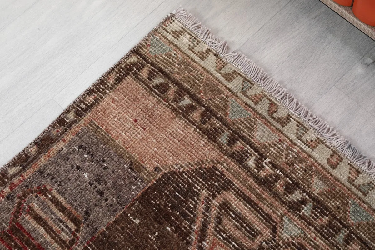 Detailed corner view of the rug, showing the outer border design and short fringes