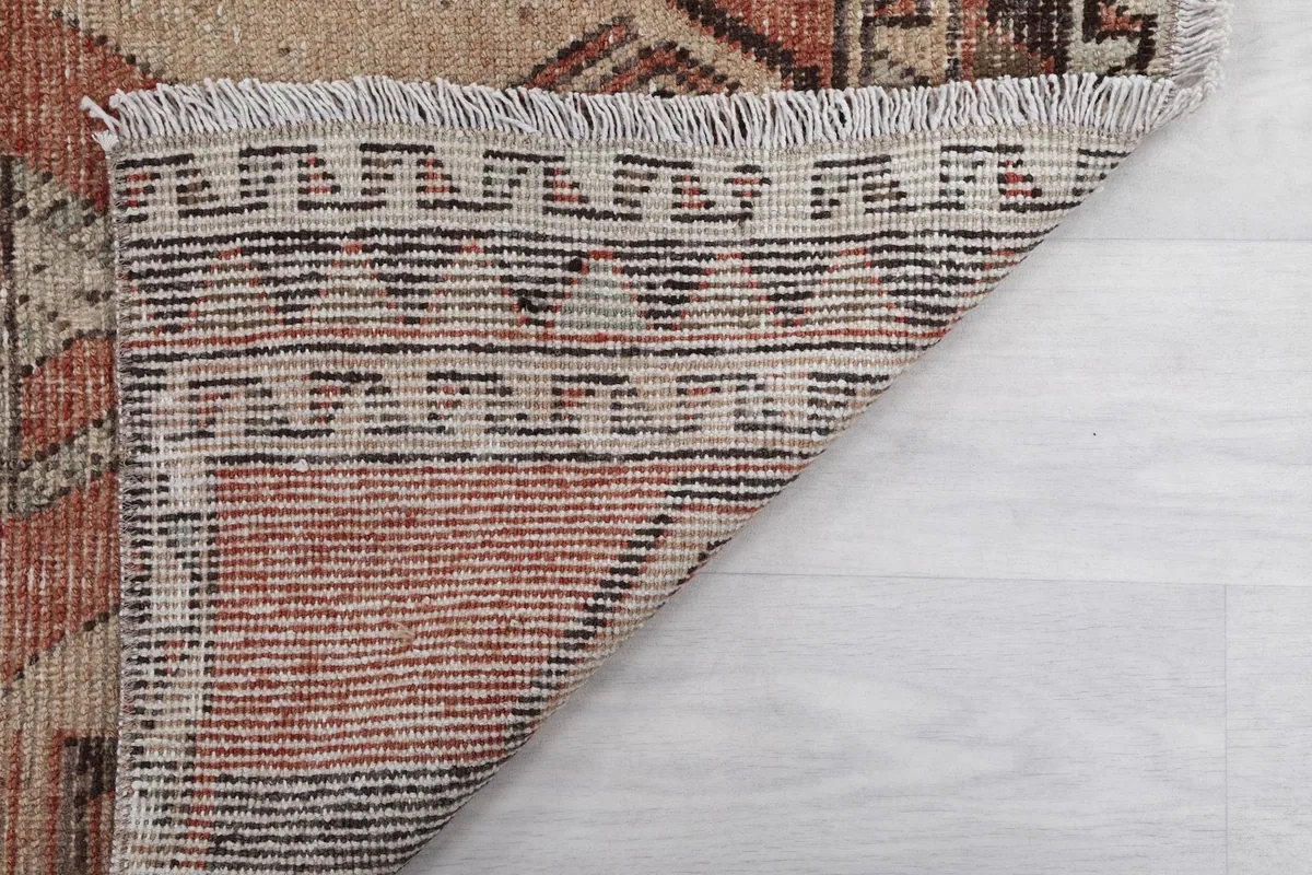 Close-up of the rug's reverse side, showing the hand-knotted construction and fringe details