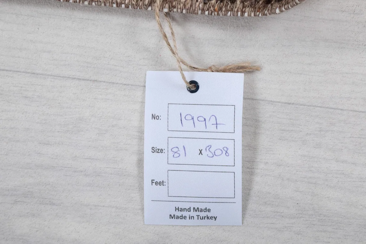 Product tag with the rug's number, size in centimeters, and 'Hand Made Made in Turkey' text