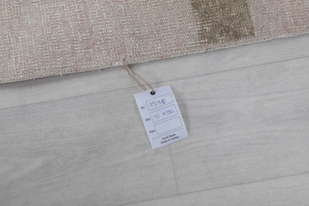 Close-up of the product tag attached to the rug, showing details like size and origin