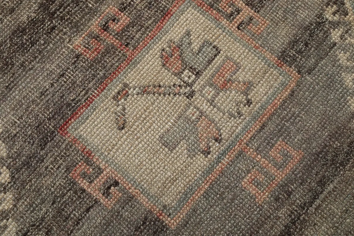 Extreme close-up of the hand-knotted wool pile and intricate geometric motifs within a medallion