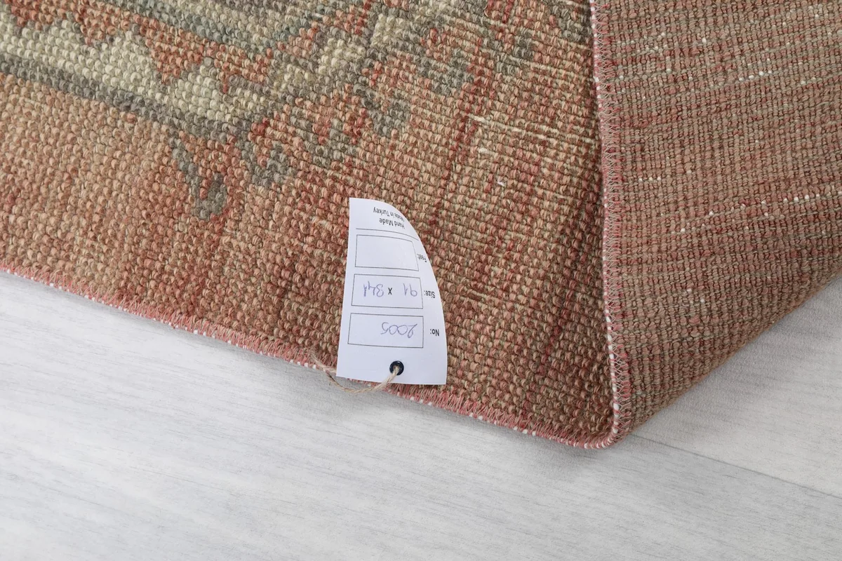 Corner of the rug with a size tag, confirming dimensions and material details