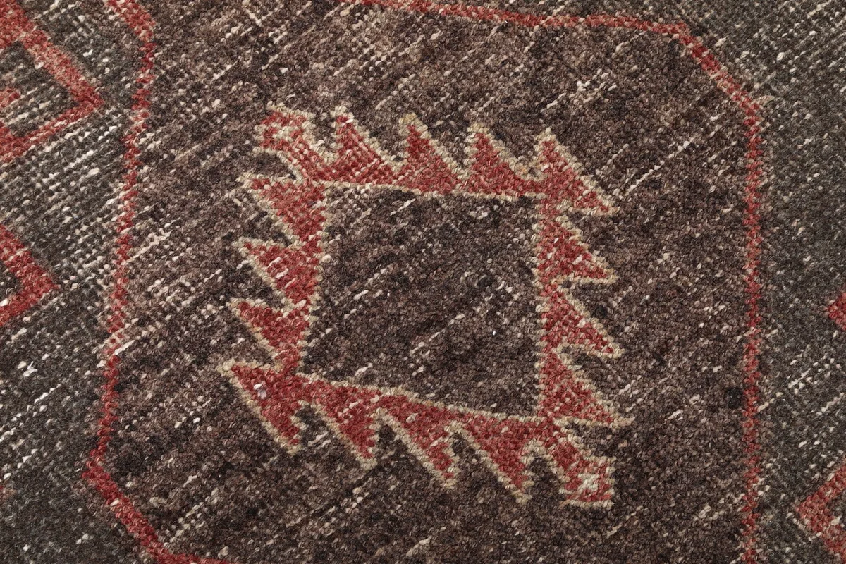 Extreme close-up of a central geometric motif, showing the hand-knotted wool pile and subtle color variations.