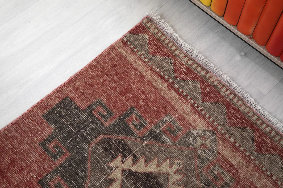 Close-up of the rug's upper border and fringe, detailing the edge finish and surrounding patterns.
