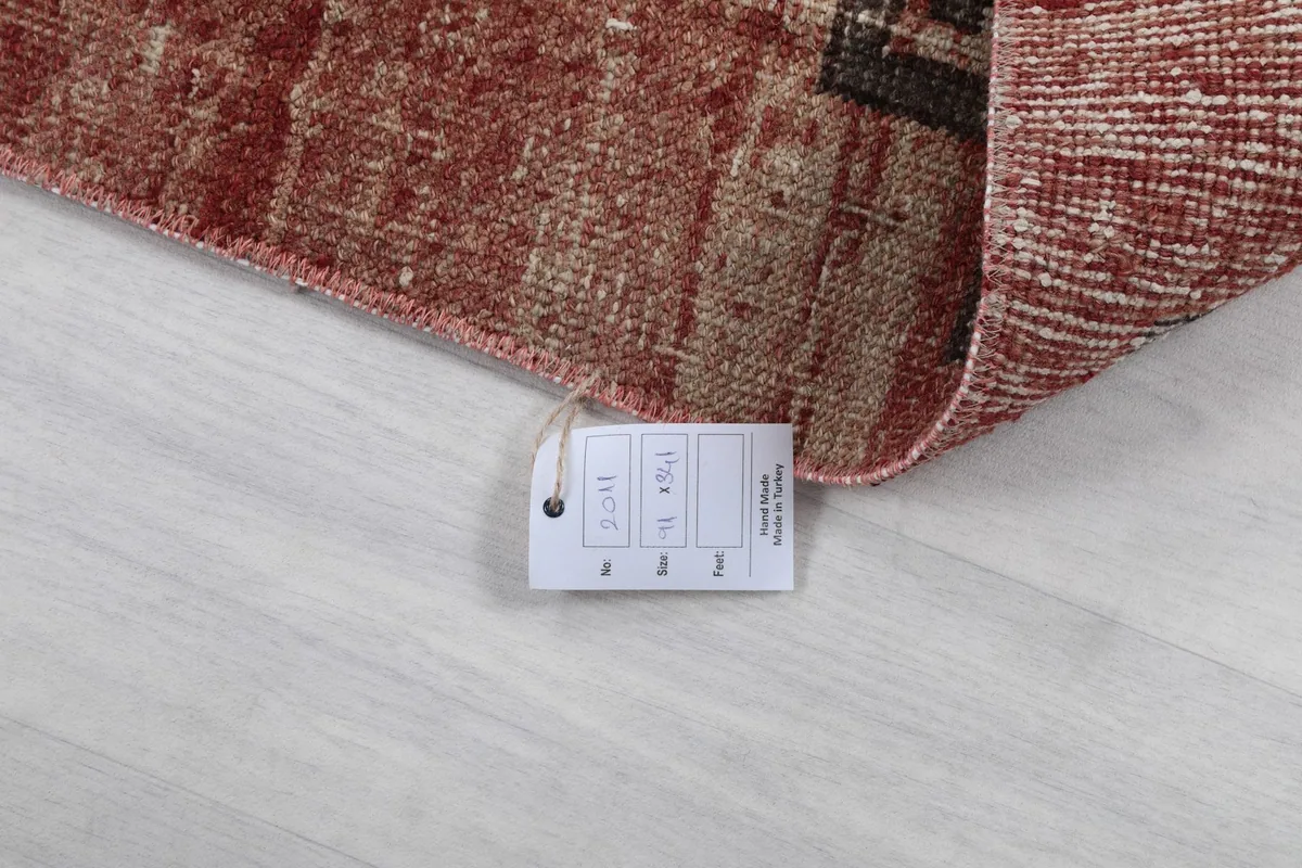Close-up of the product tag attached to the rug, displaying size and material information.