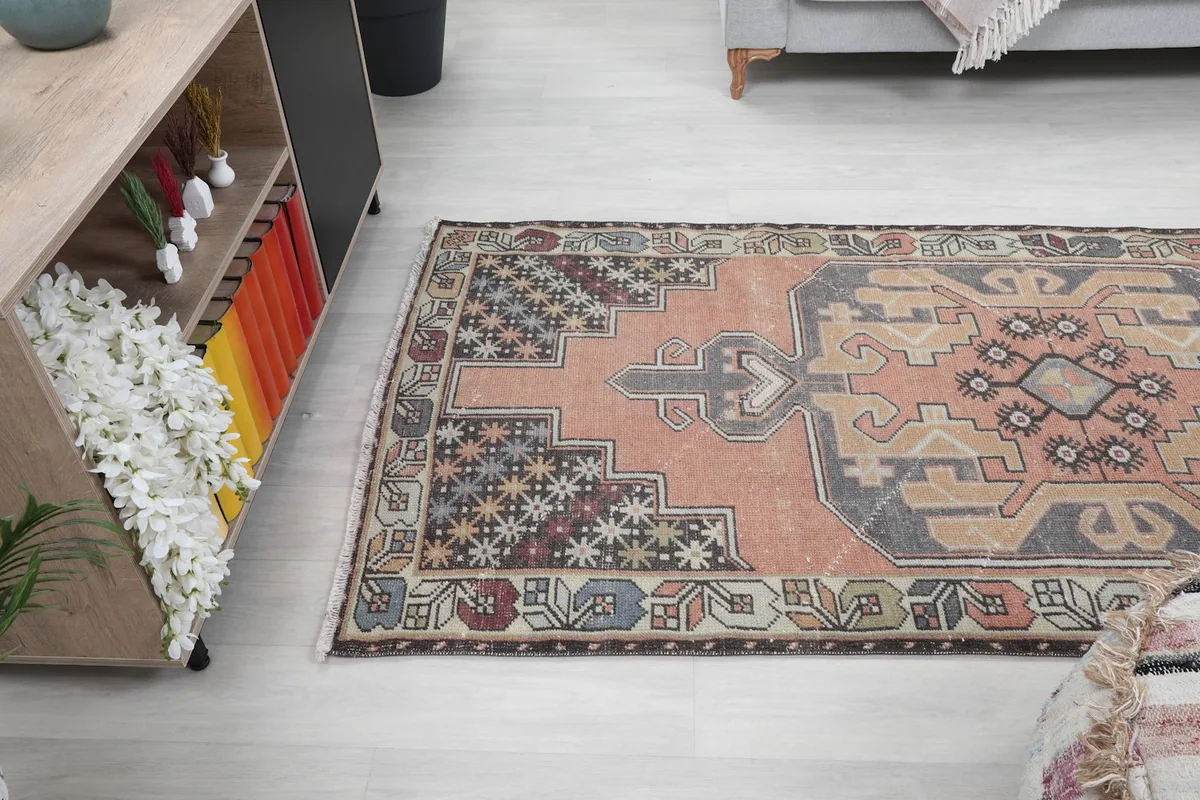 Angled view of the rug, showing its length in the room, with a gray sofa and a wooden console table