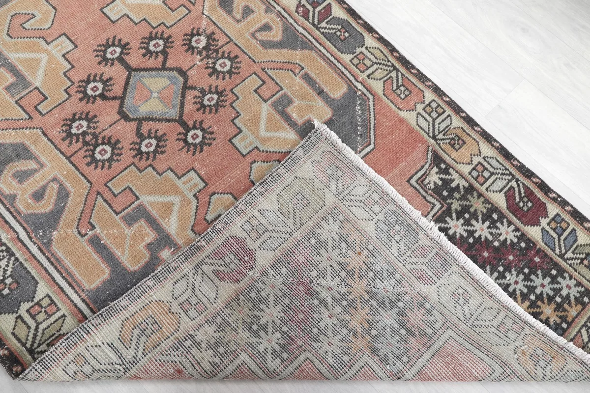 Flipped corner of the rug showing the hand-knotted wool pile and cotton foundation from the back