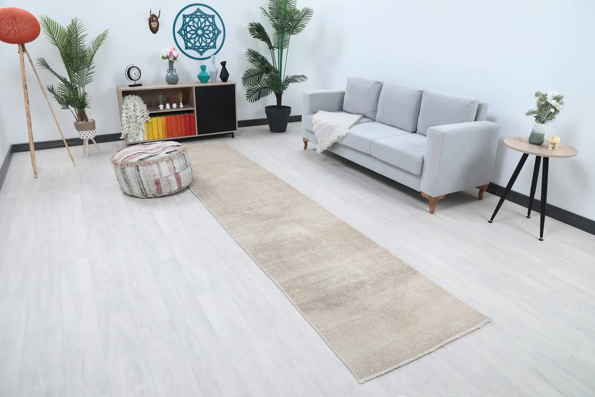 Angled view of the beige runner rug extending through a living space with minimal decor.
