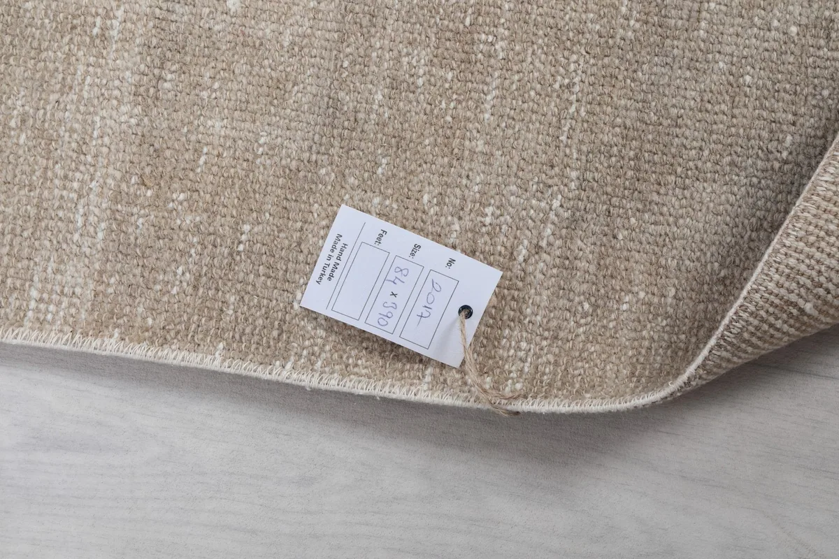 Close-up of the rug's label, displaying size and origin information, tucked into a folded corner.