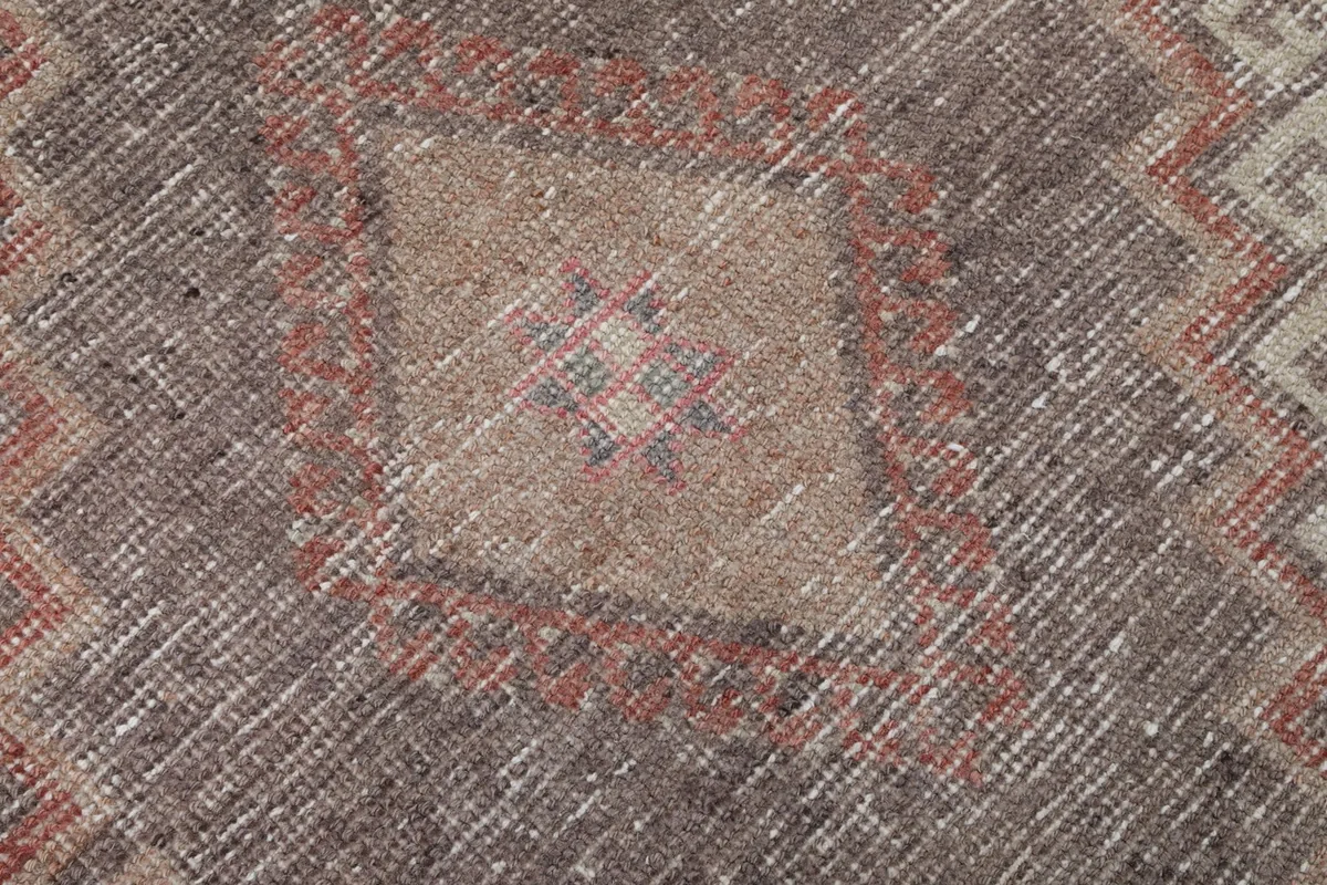 Close-up of the faded wool pile and intricate details within a geometric pattern