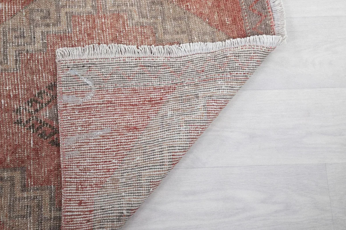 Underside of the rug showing the tightly woven cotton foundation and short fringes