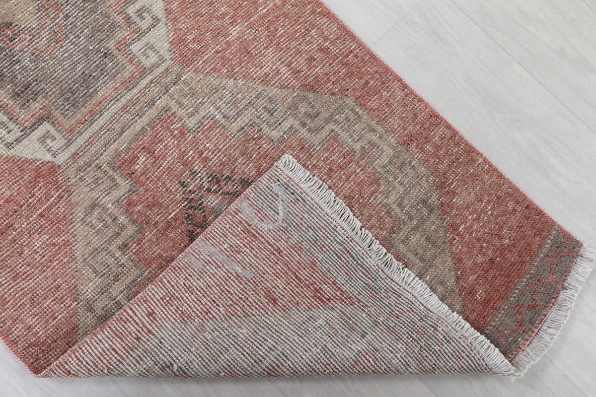 Folded corner of the rug revealing the cotton foundation and hand-knotted construction
