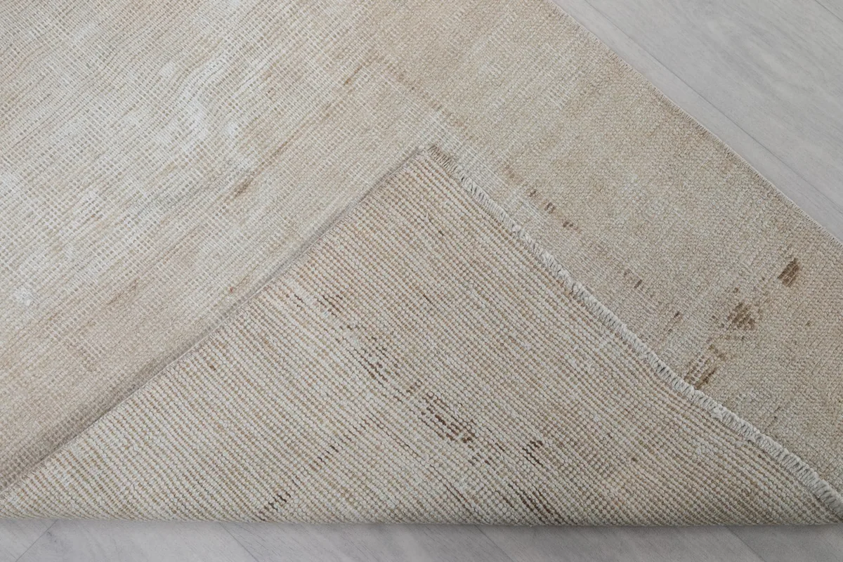 Underside of the rug, folded to reveal the hand-knotted cotton foundation
