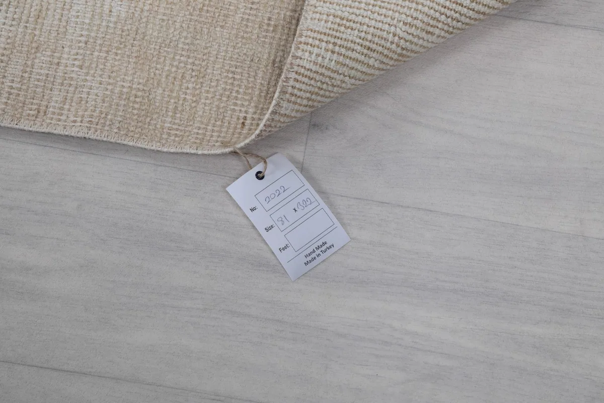 Product tag attached to the rug, displaying details like origin and material