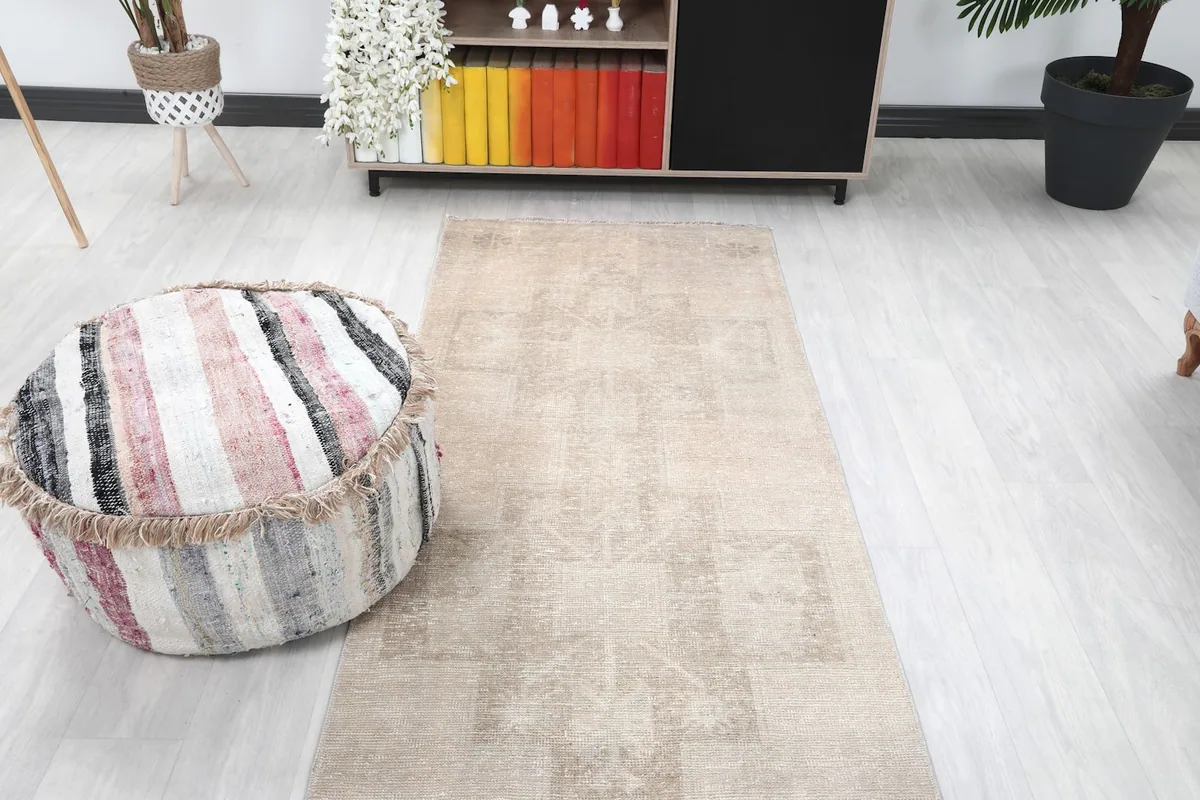 Overhead room view of the beige runner rug, centered in a living area with furniture.