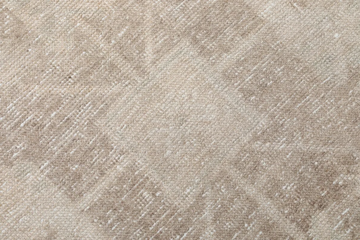 Close-up of the low wool pile and the intricate weave of the beige and gray geometric pattern.