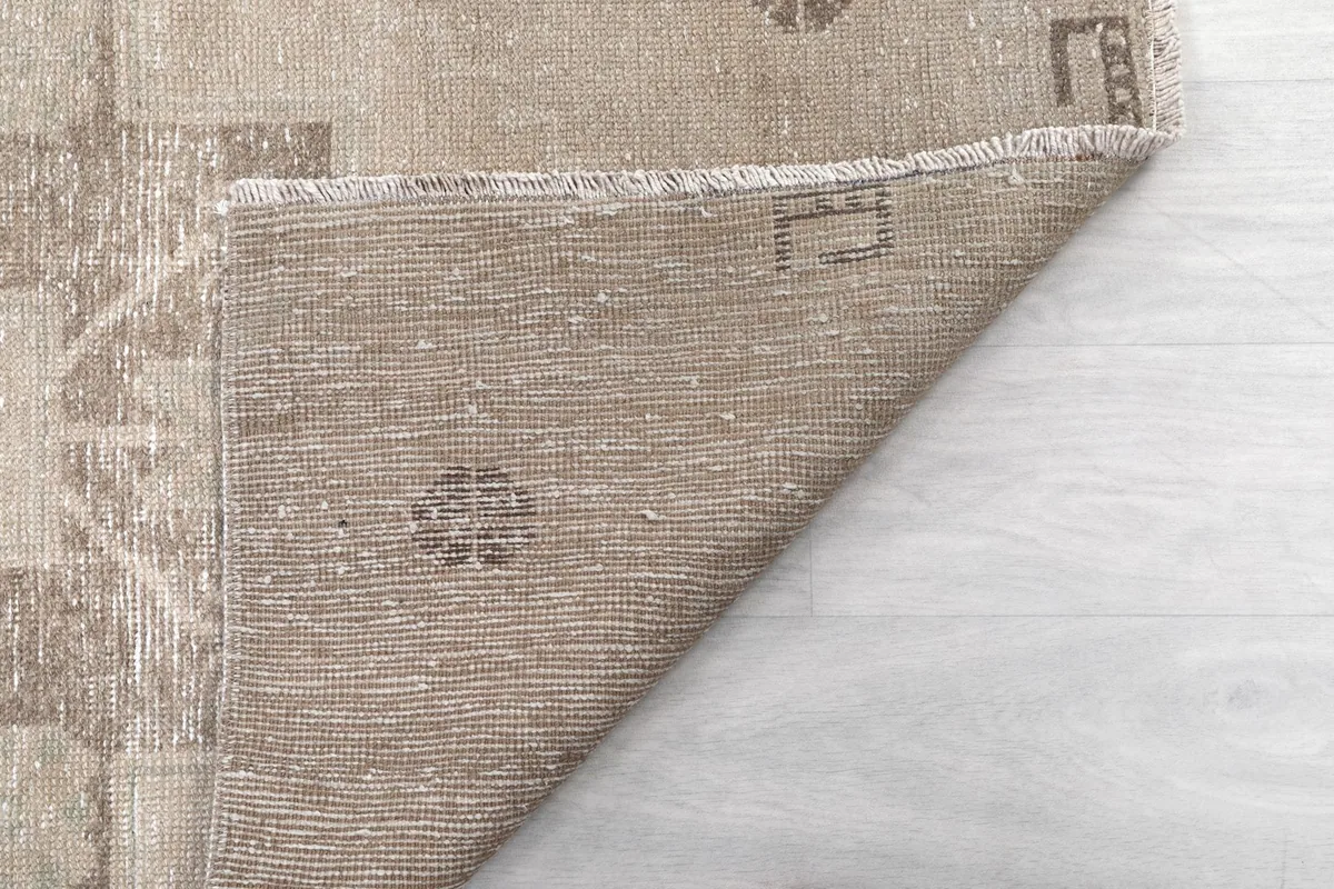 Another view of the back of the beige runner, revealing the craftsmanship and tight weave of the rug.