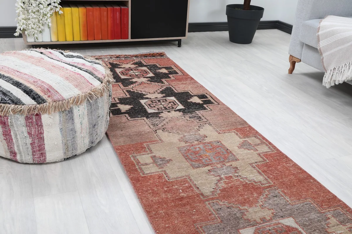 Close-up angle showing the runner rug's geometric pattern and colors next to a striped ottoman.