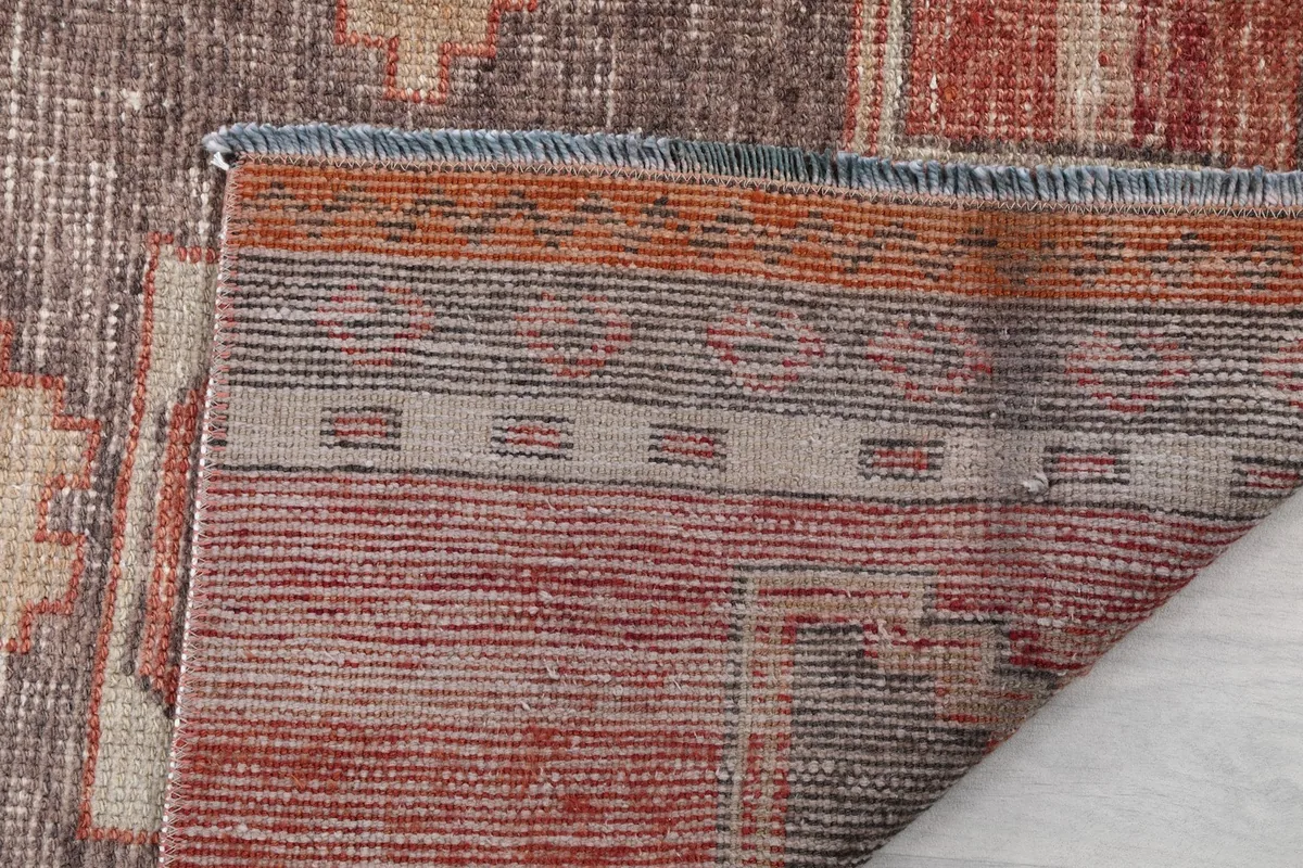 Close-up showing the low wool pile and the tightly woven cotton foundation of the rug.