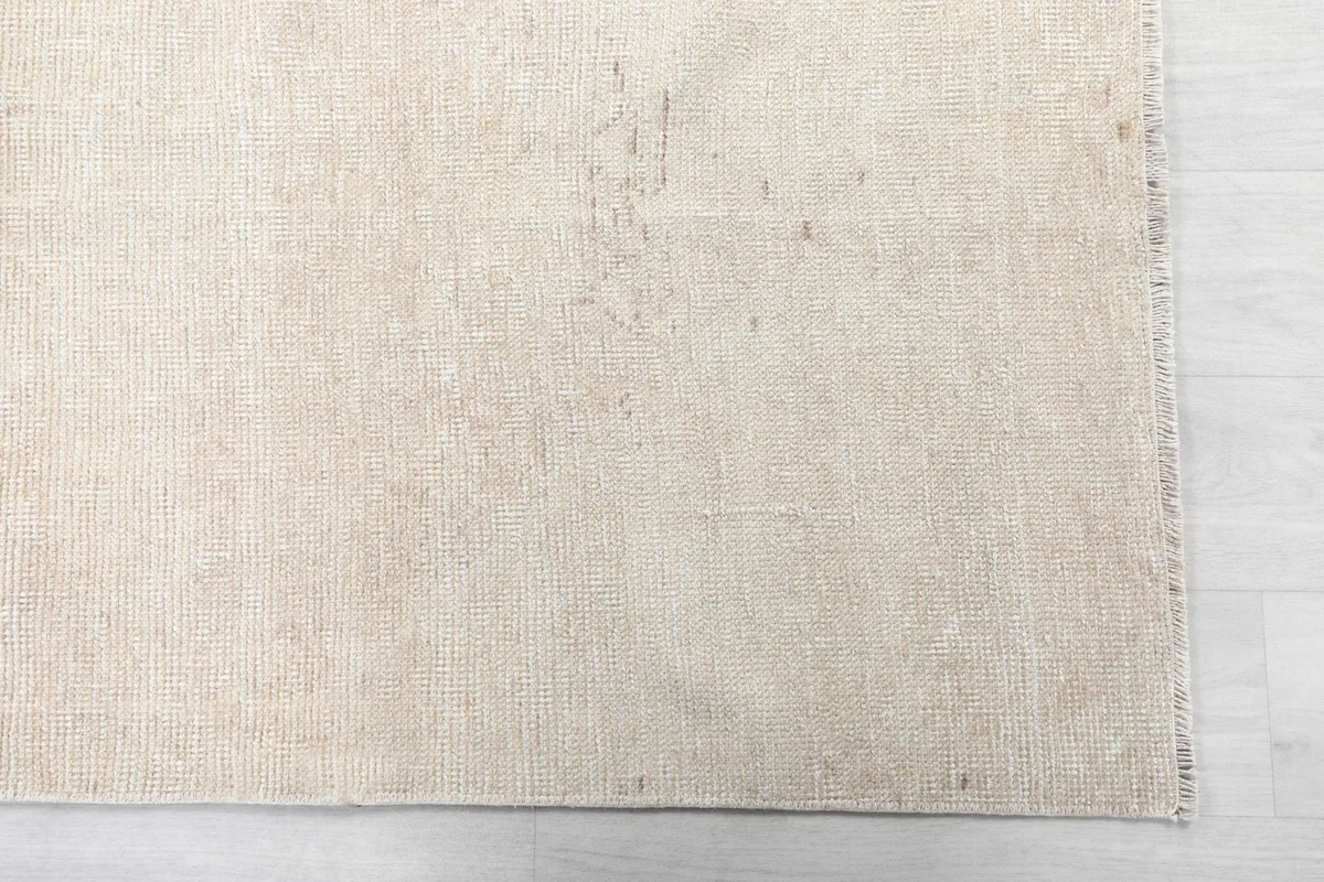 Detailed view of the rug's surface, showing the hand-knotted wool pile and light patina