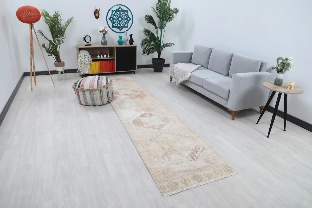 Angled view of the beige and tan runner rug in a living room setting, highlighting its placement.